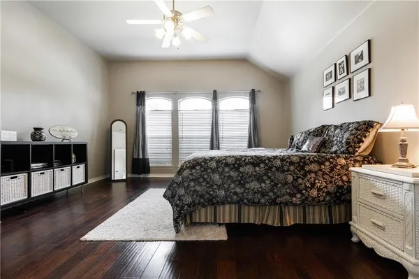 a bedroom with a large bed and a wooden floor