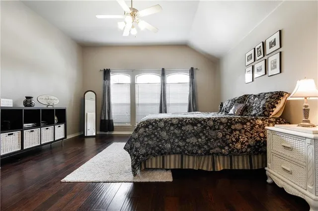 a bedroom with a large bed and a wooden floor
