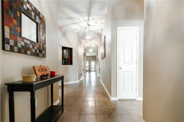 a hallway with a table and chairs