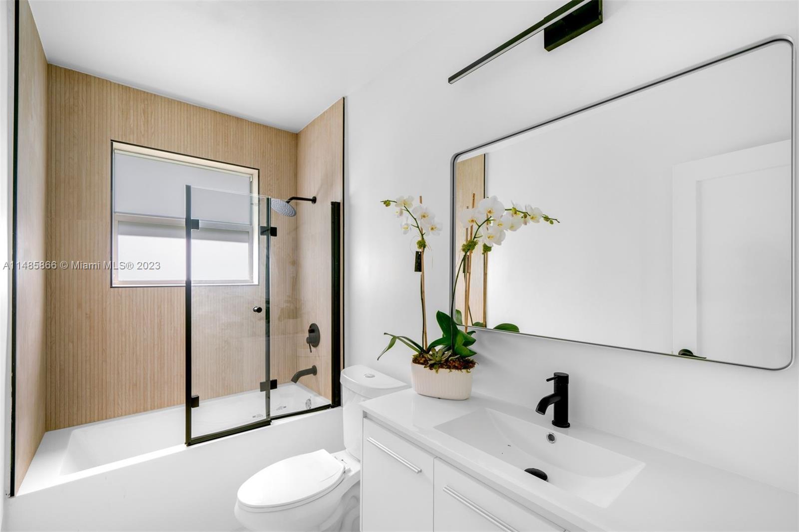 2385 North Bay Road Miami Beach, FL 33140 - Photo 20 of 36 a bathroom with a toilet a sink and a mirror