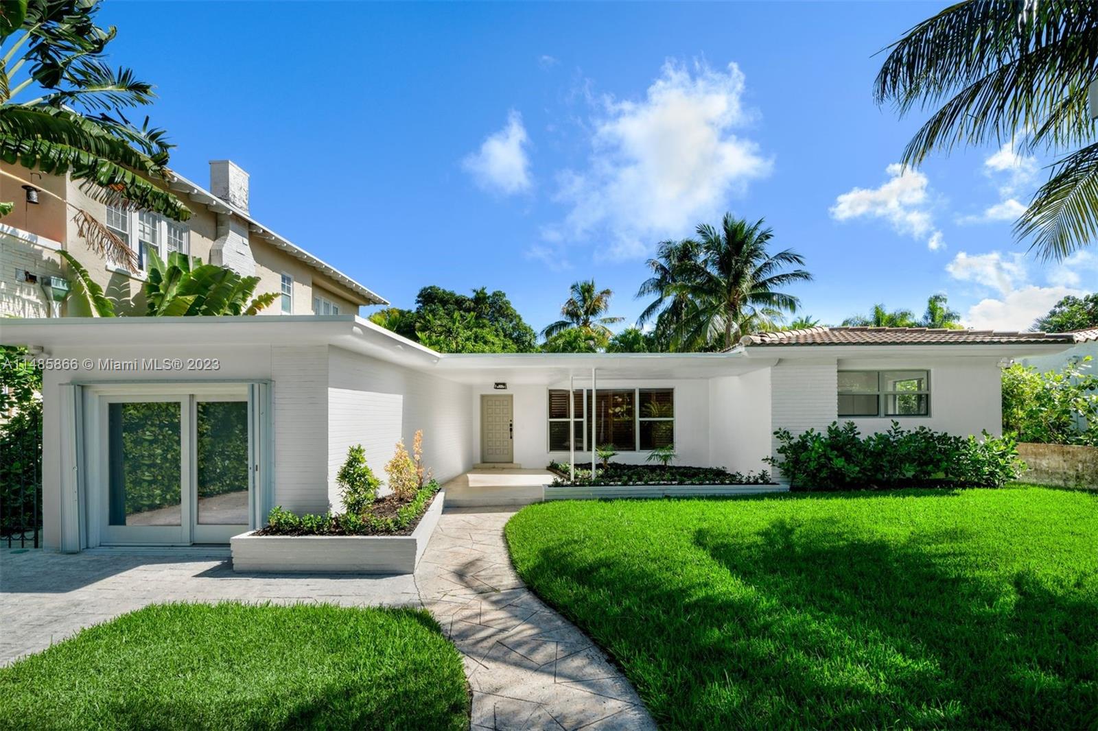 2385 North Bay Road Miami Beach, FL 33140 - Photo 3 of 36 a front view of house with yard and green space