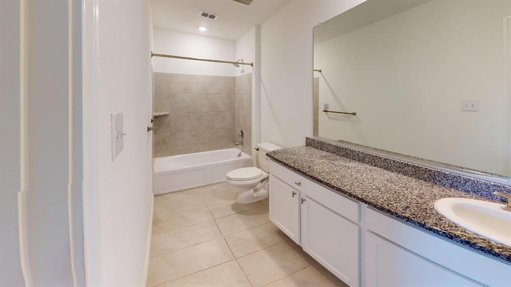 403 Ashbrook Way Princeton, TX 75407 - Photo 11 of 23 Bathroom featuring a vanity with a speckled countertop and integrated sink, a large wall-mounted mirror, a tub/shower combination with tiled surround, and recessed lighting