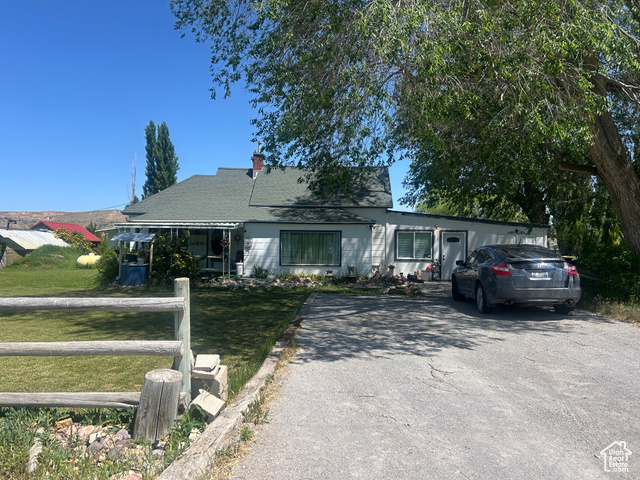 1157 East 3200 Road North Preston, ID 83263 - Photo 1 of 1 View of front of house featuring a front yard, a chimney, asphalt driveway, and a shingled roof