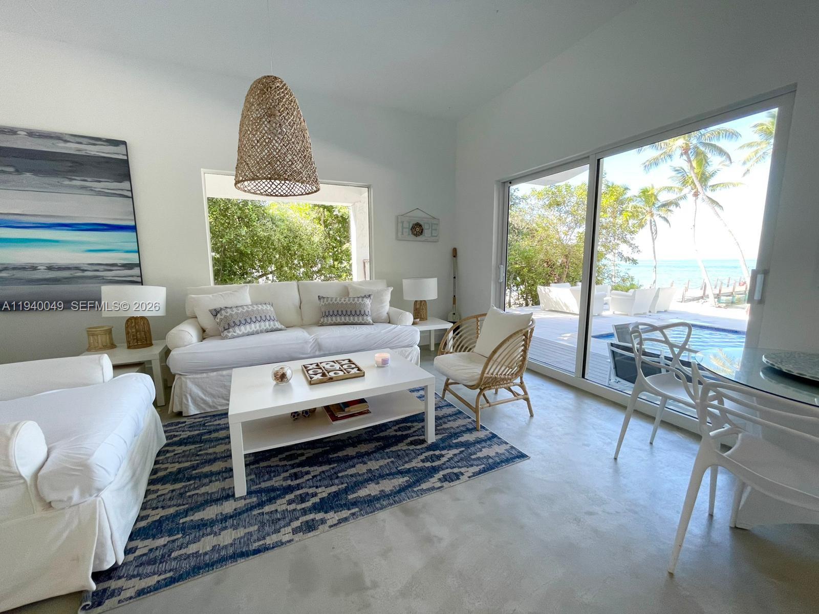 96180 Overseas Highway, Unit 1 Key Largo, FL 33037 - Photo 14 of 83 a living room with furniture a fireplace and a floor to ceiling window