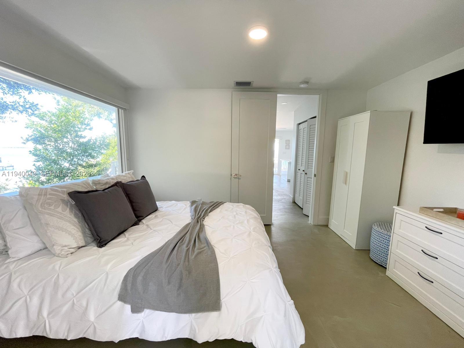 96180 Overseas Highway, Unit 1 Key Largo, FL 33037 - Photo 23 of 83 a bedroom with a bed and a flat tv screen