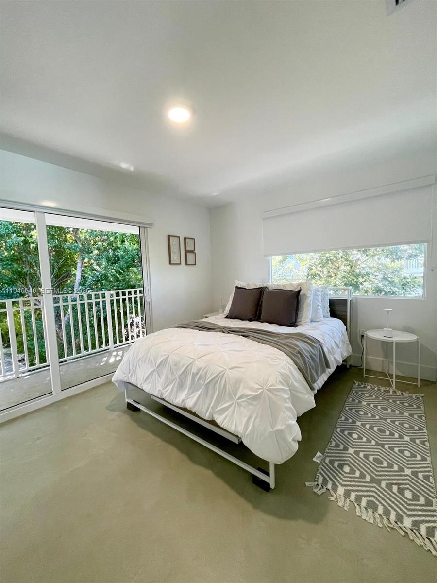 96180 Overseas Highway, Unit 1 Key Largo, FL 33037 - Photo 36 of 83 a bedroom with a bed and a view of balcony