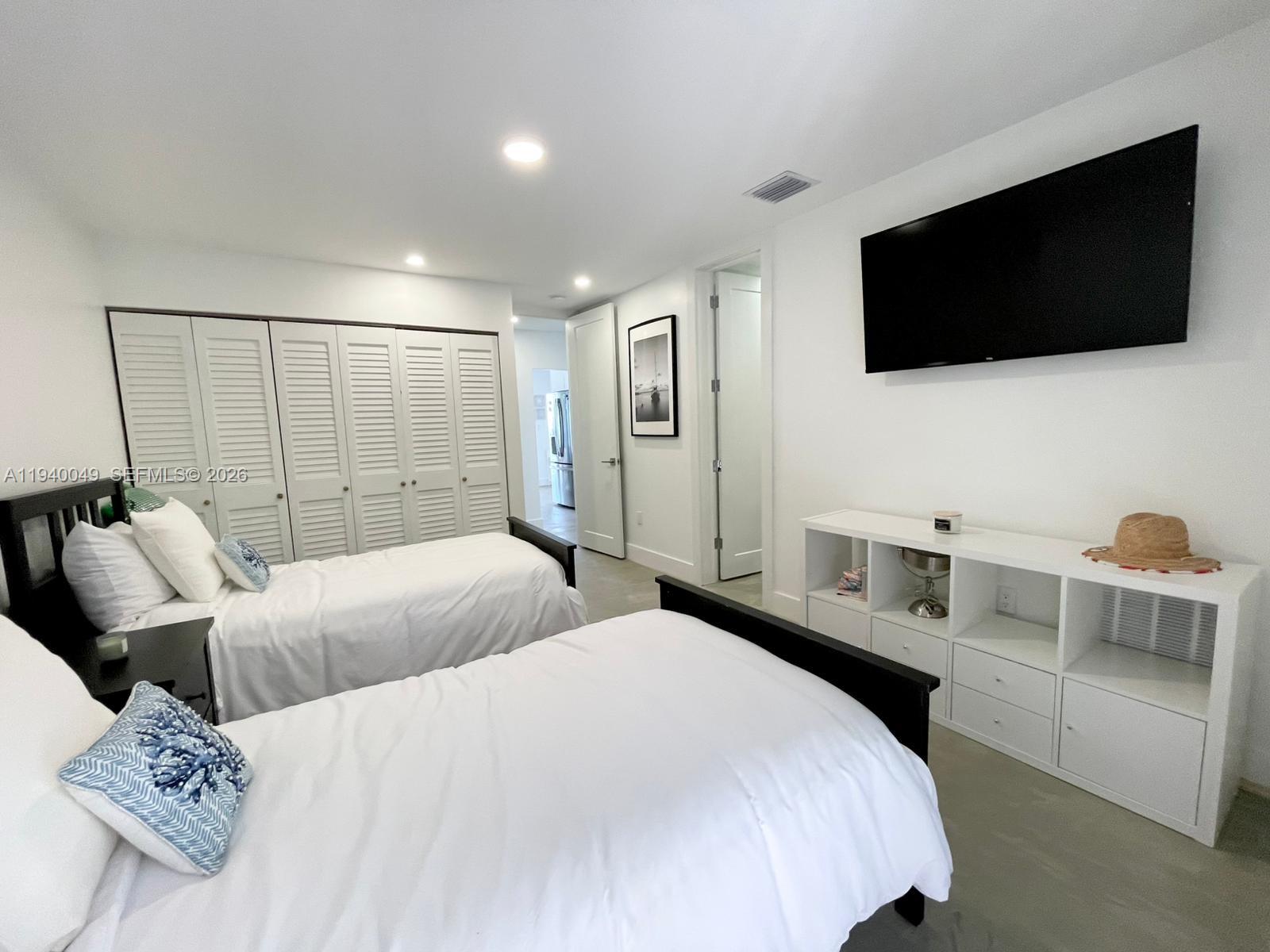 96180 Overseas Highway, Unit 1 Key Largo, FL 33037 - Photo 37 of 83 a bedroom with a bed a television and a large window