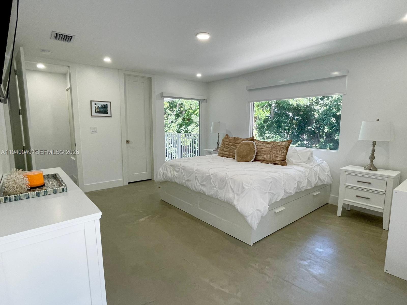 96180 Overseas Highway, Unit 1 Key Largo, FL 33037 - Photo 44 of 83 a bedroom with a bed and a view of bathroom