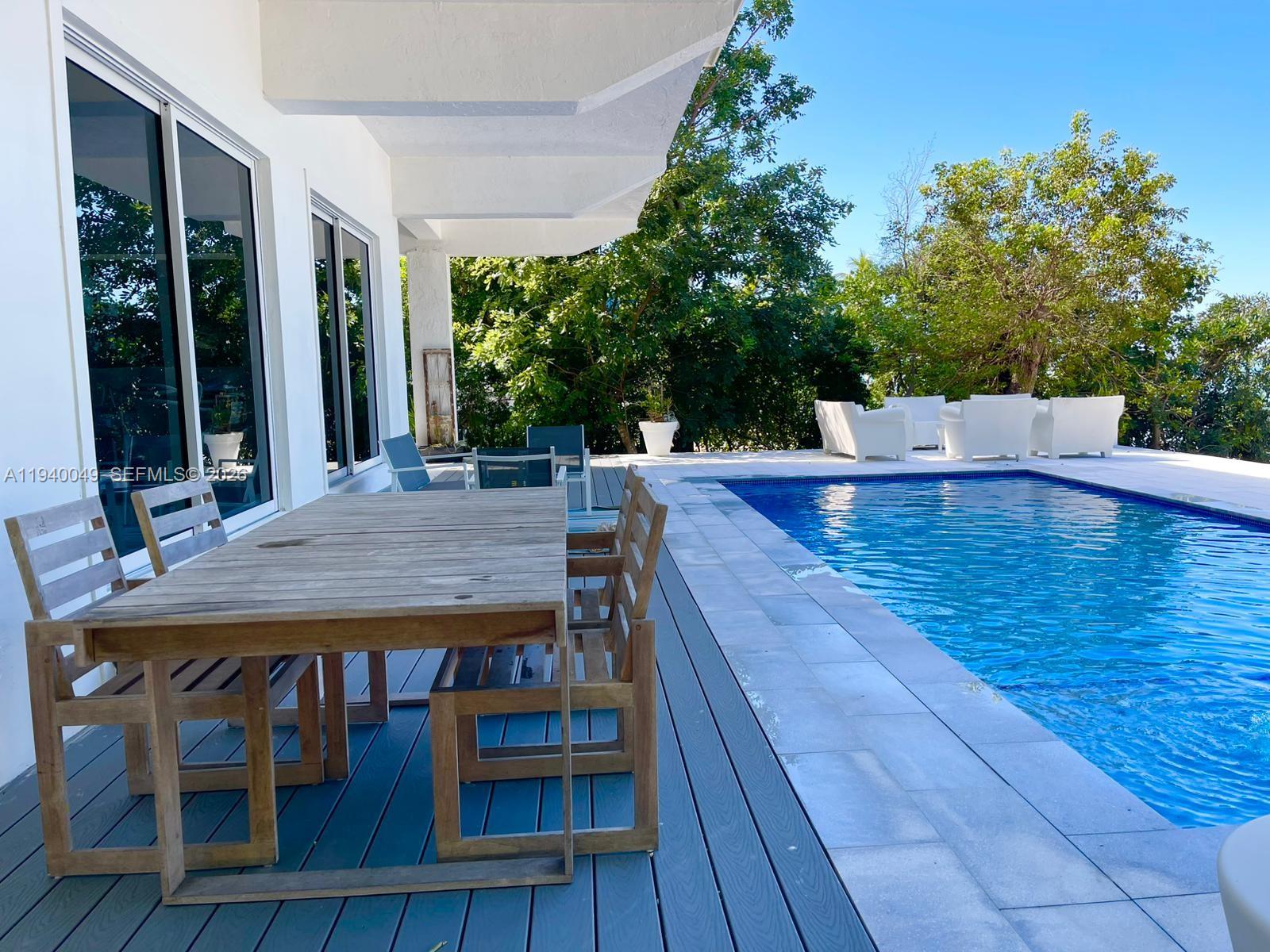 96180 Overseas Highway, Unit 1 Key Largo, FL 33037 - Photo 55 of 83 a view of a patio with table and chairs with wooden floor and fence