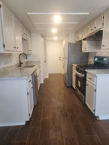 a kitchen with stainless steel appliances granite countertop a sink stove and refrigerator