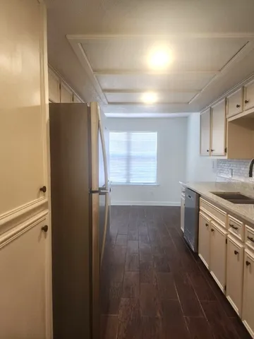 a kitchen with a refrigerator sink and cabinets