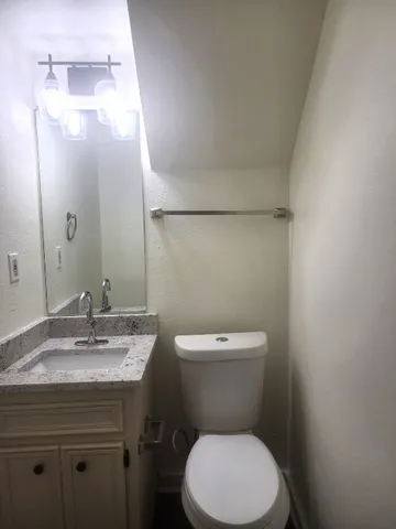 a bathroom with a toilet a sink and mirror