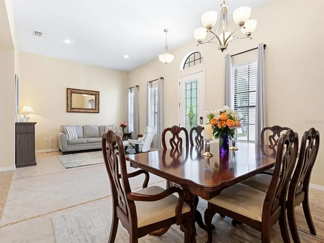 a kitchen with a table chairs refrigerator and microwave