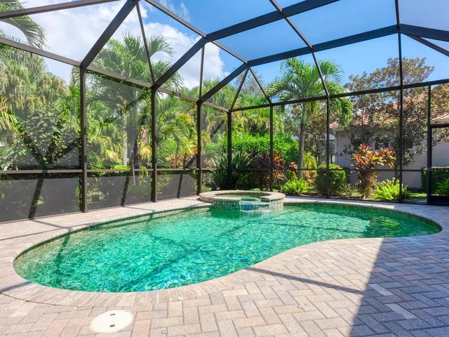 a view of a house with a yard and palm trees