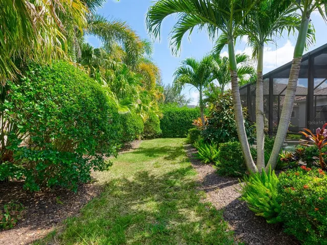 a kitchen with stainless steel appliances granite countertop a stove a refrigerator a oven a sink a dining table and chairs