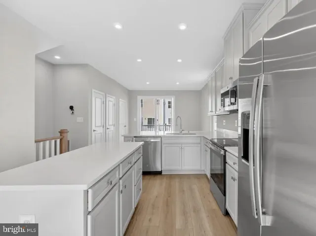 a kitchen with white cabinets and stainless steel appliances