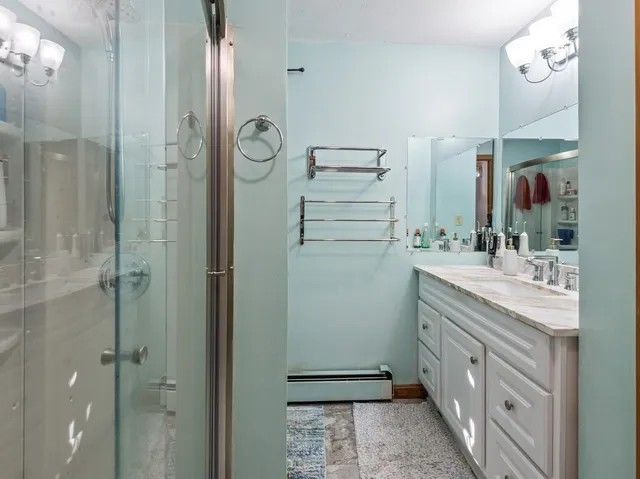 a bathroom with a double vanity sink mirror and shower