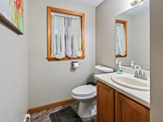 a bathroom with a toilet a sink and mirror