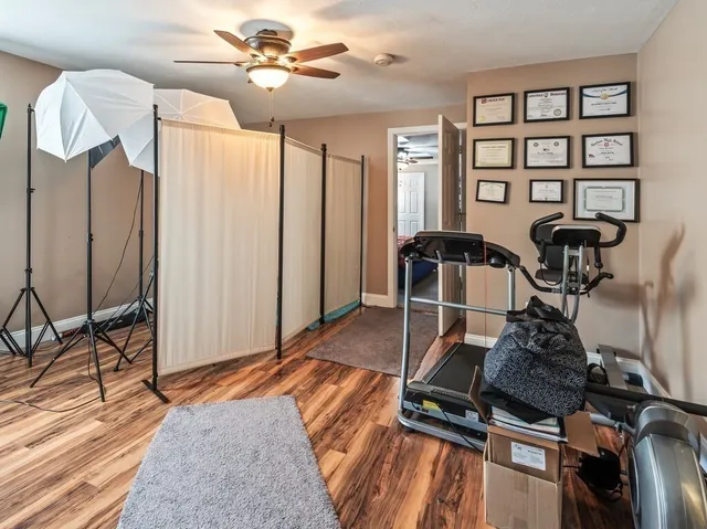 a room with gym equipment and wooden floor