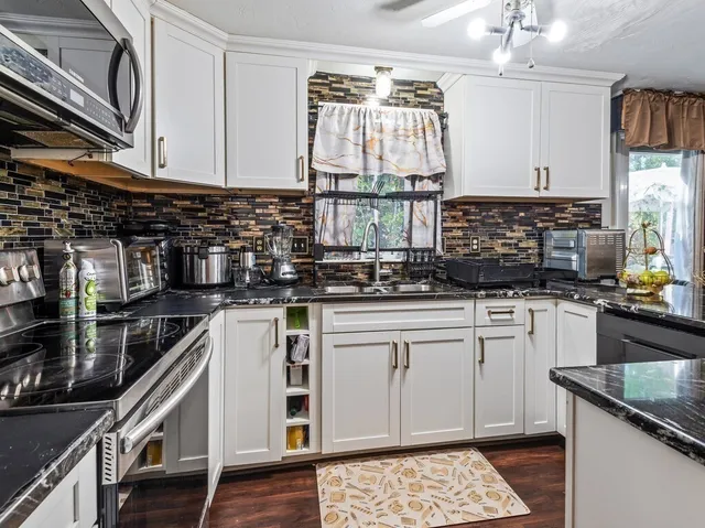 a kitchen with a white cabinets and wooden floor