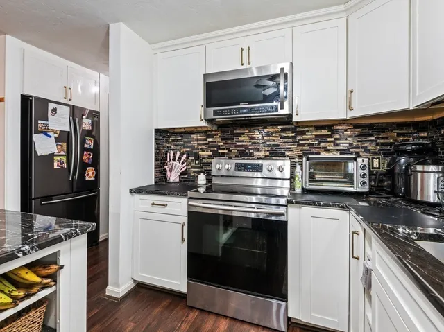 a kitchen with stove a microwave and cabinets