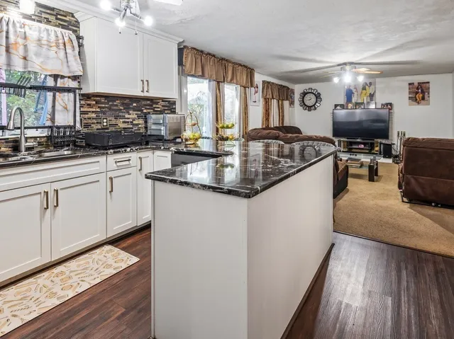 a kitchen with stainless steel appliances granite countertop a sink stove and cabinets