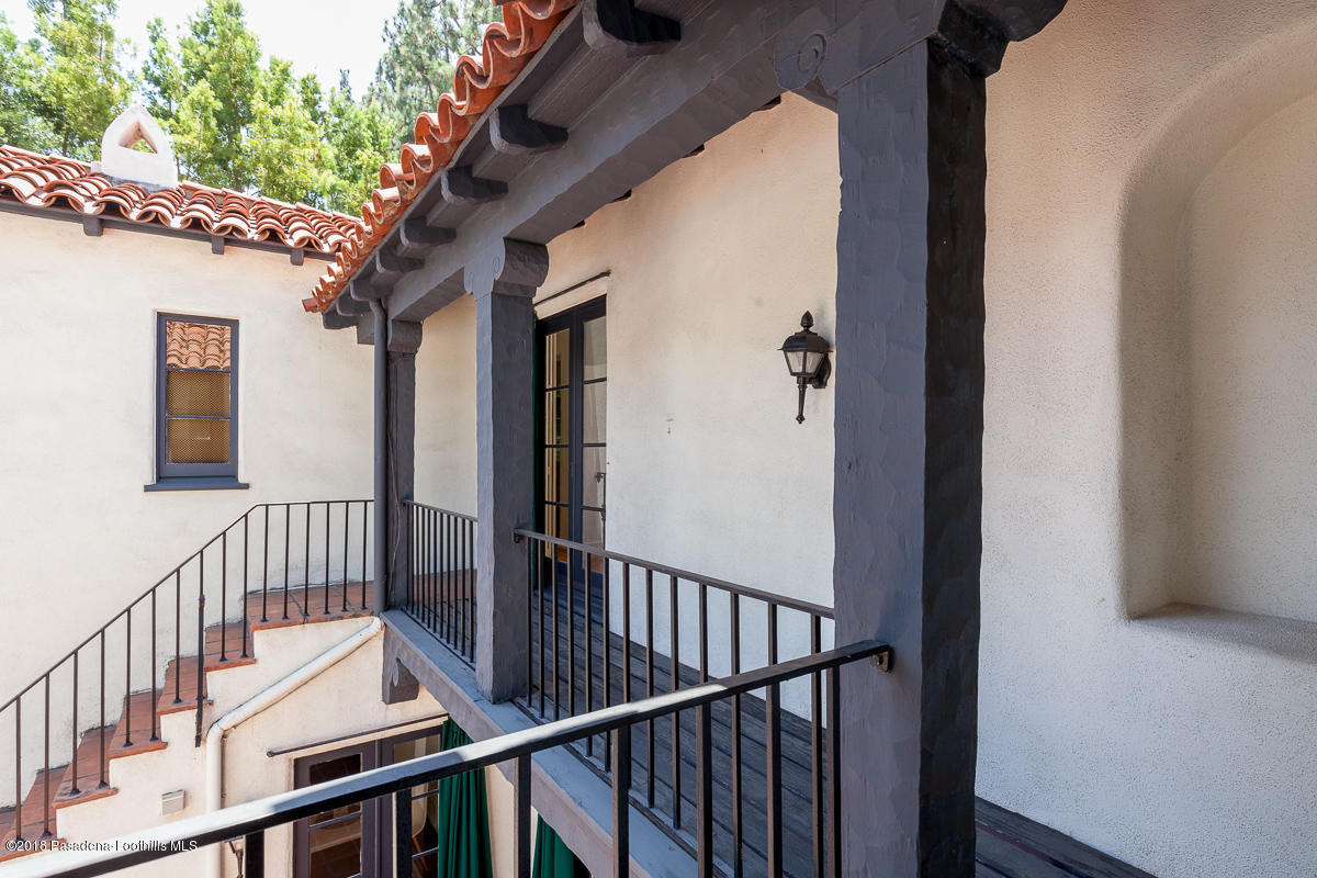 700 South Orange Grove Boulevard Pasadena, CA 91105 - Photo 43 of 50 a view of a porch with wooden floor and iron fence