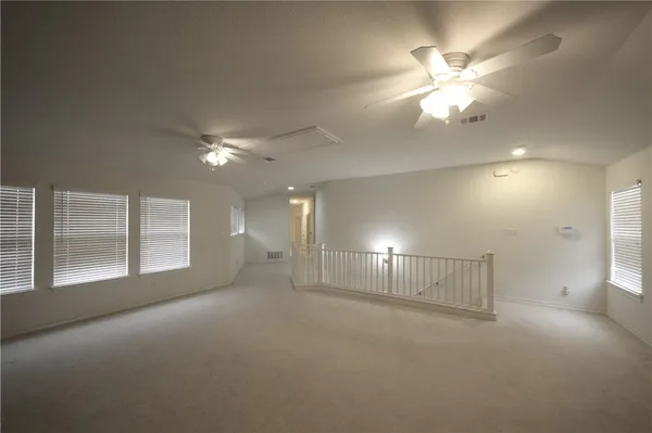 a view of an empty room with a chandelier fan