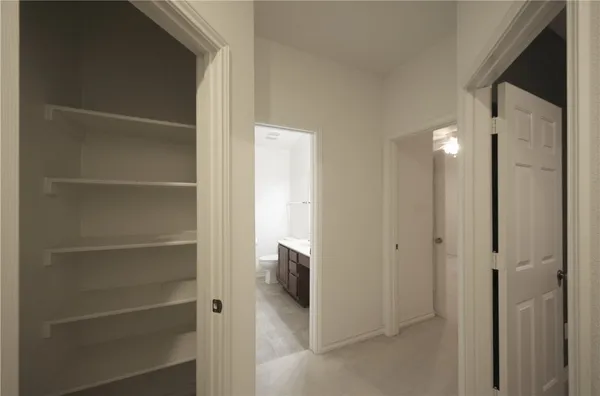 a view of a hallway with wooden shelves