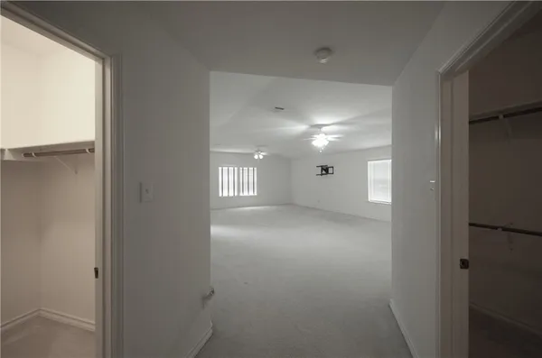en empty room with windows and ceiling fan