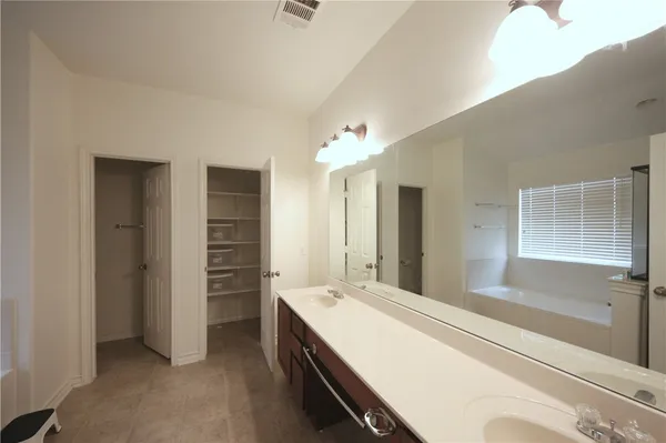 a bathroom with a tub sink and mirror