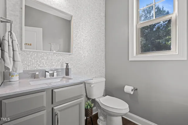 a bathroom with a granite countertop toilet sink and mirror