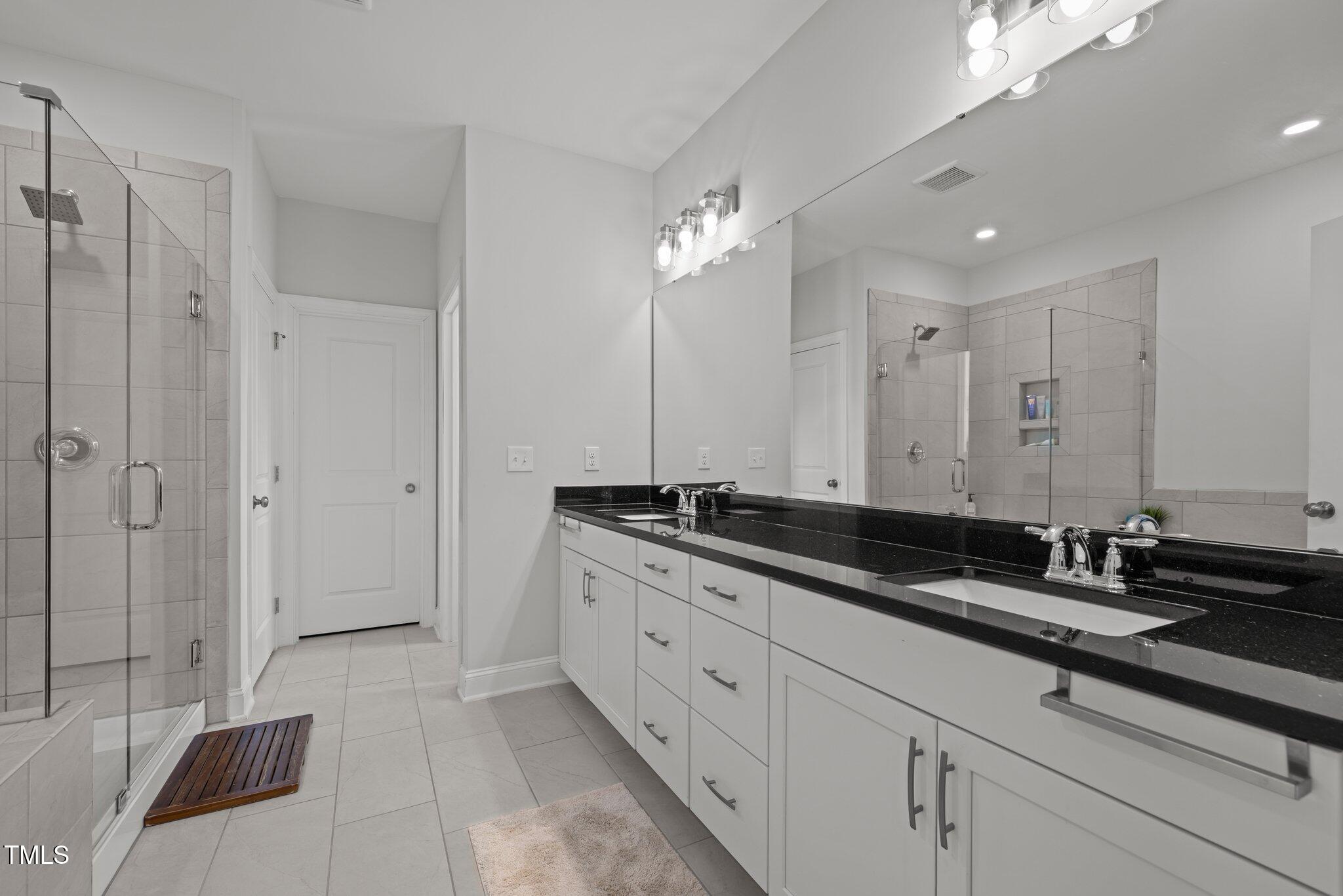 98 Stone Bridge Crossing Chapel Hill, NC 27517 - Photo 15 of 37 a spacious bathroom with a double vanity sink a large mirror and a shower