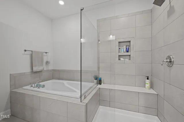 a bathroom with a tub a window and a shower