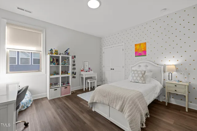 a bedroom with a bed and a bookshelf with wooden floor