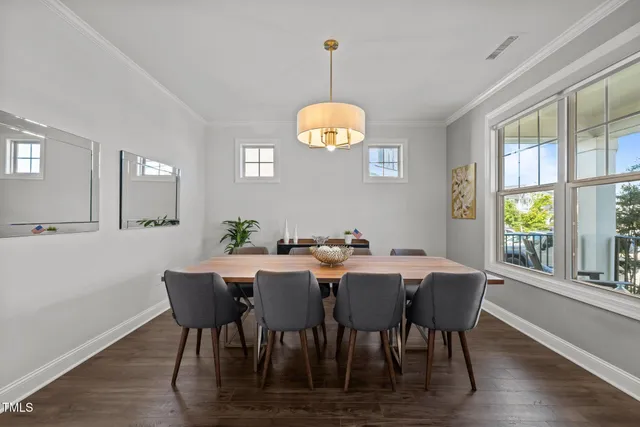 a view of a dining room with furniture a chandelier and wooden floor