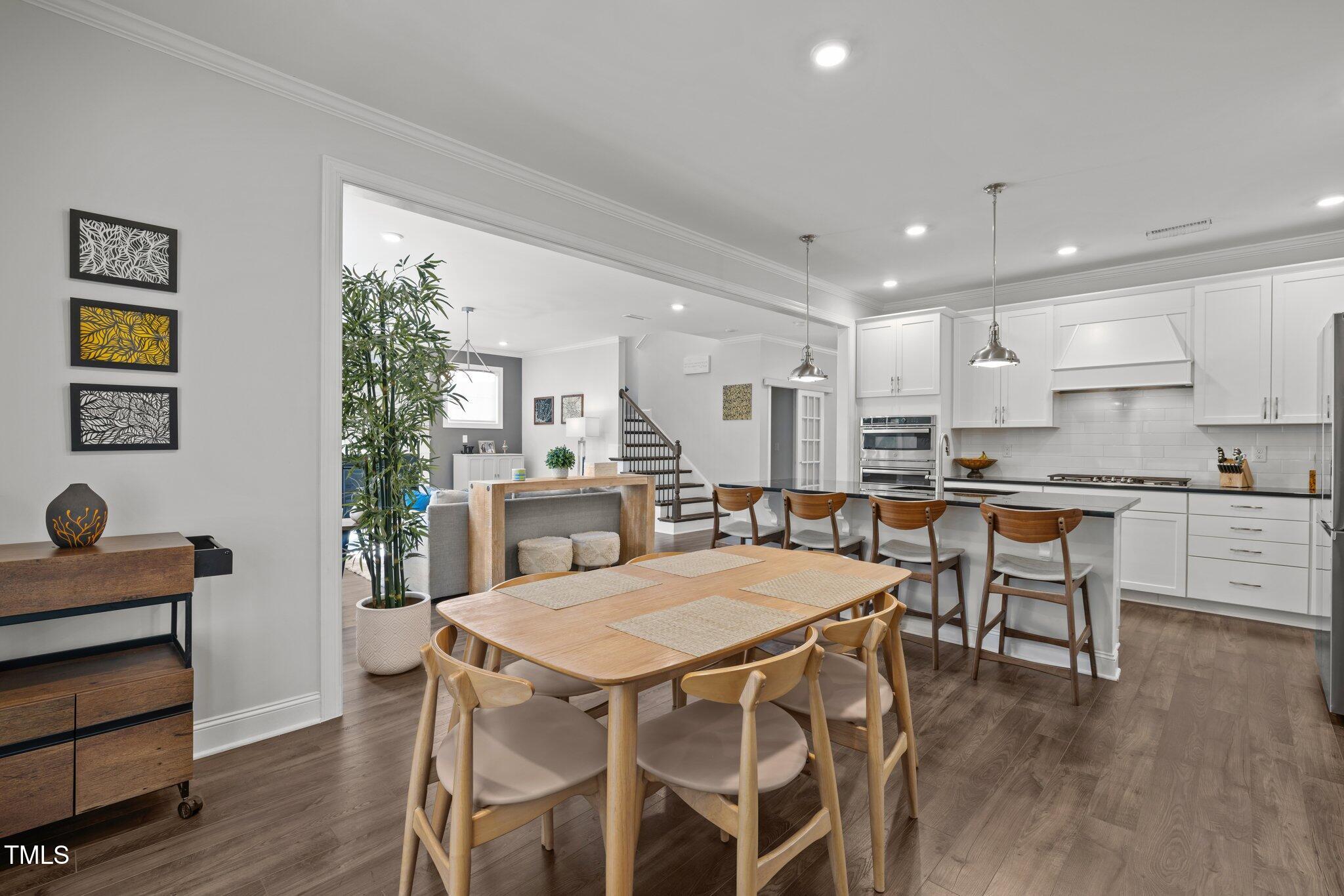 98 Stone Bridge Crossing Chapel Hill, NC 27517 - Photo 6 of 37 a kitchen with a dining table chairs refrigerator and cabinets