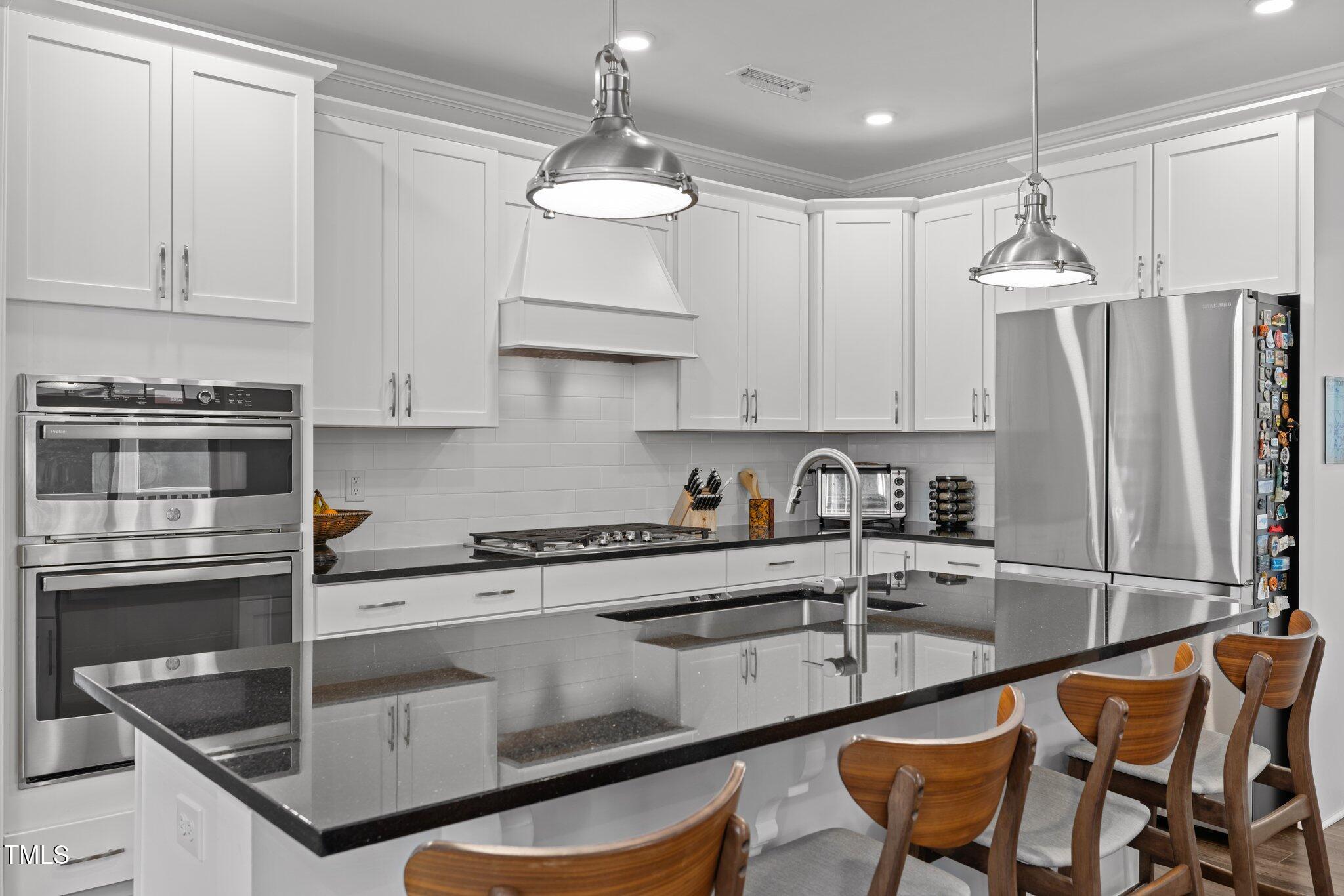 98 Stone Bridge Crossing Chapel Hill, NC 27517 - Photo 8 of 37 a kitchen with stainless steel appliances granite countertop a sink a stove a refrigerator and cabinets