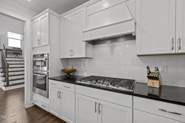 a kitchen with white cabinets and appliances