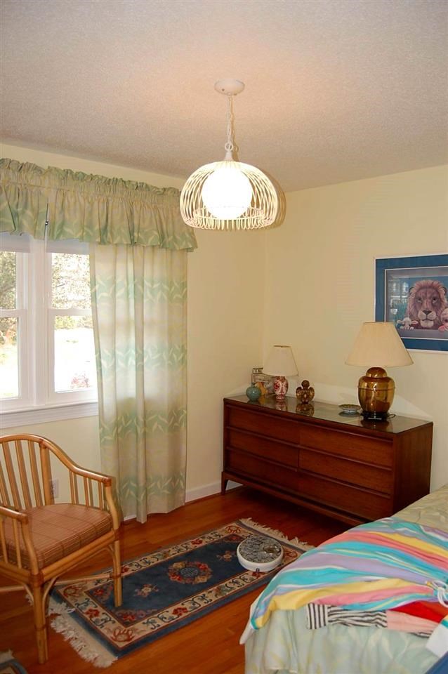 800 Purdue Street Raleigh, NC 27609 - Photo 15 of 21 a bedroom with a bed and a chandelier