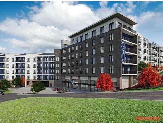 a front view of building with yard and sign board