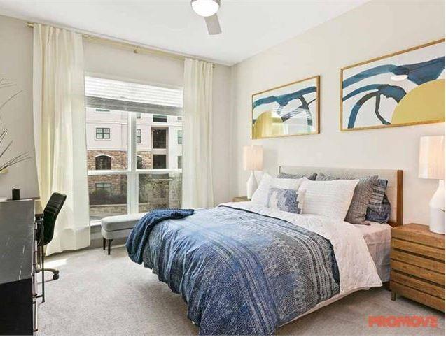 3158 Stillhouse Creek Drive, Unit 302 Atlanta, GA 30339 - Photo 4 of 6 a bedroom with a bed and a painting on the wall