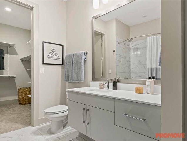 3158 Stillhouse Creek Drive, Unit 302 Atlanta, GA 30339 - Photo 5 of 6 a bathroom with a toilet sink and mirror