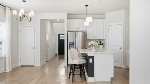a view of a kitchen area with furniture and wooden floor