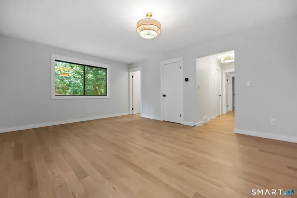 a spacious bedroom with a bed and a chandelier