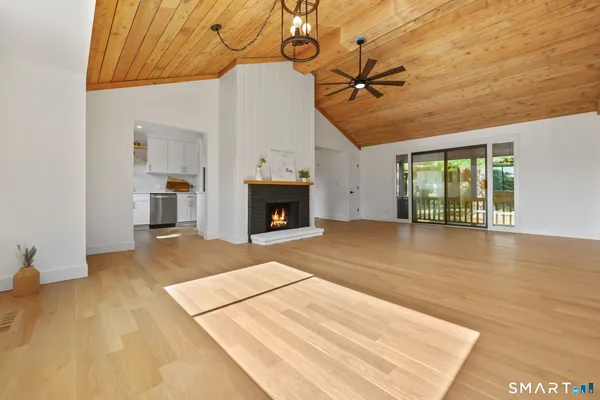a view of an empty room with a fireplace and a window