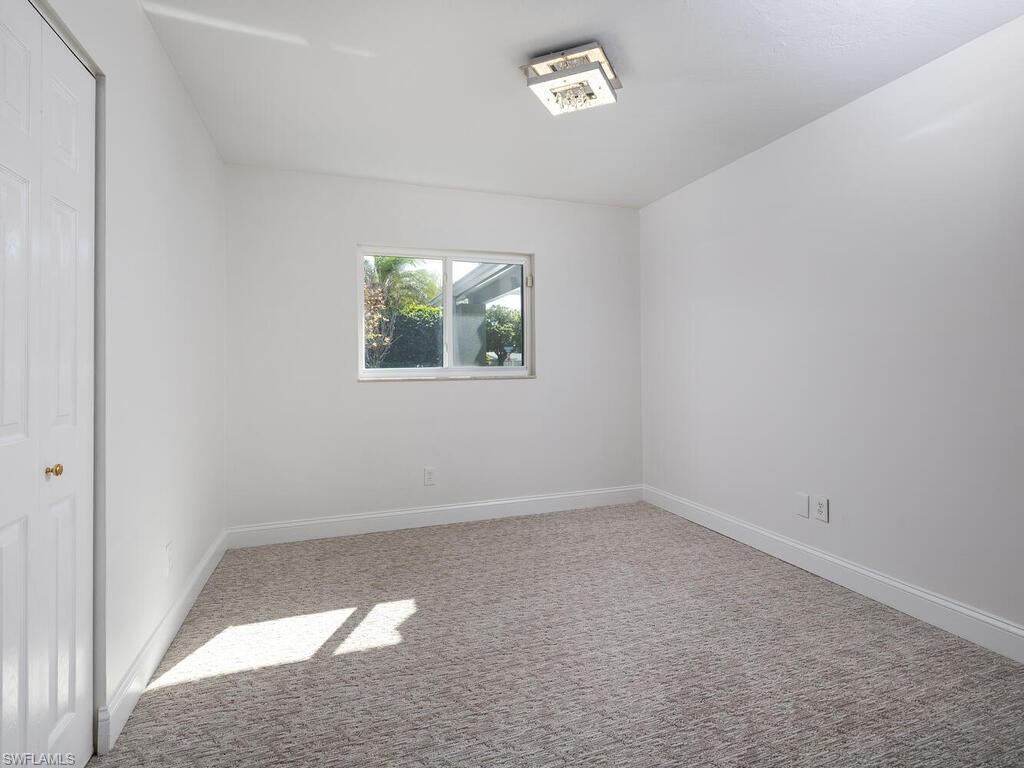 1036 Lake Shore Court Naples, FL 34103 - Photo 11 of 15 Carpeted empty room featuring baseboards