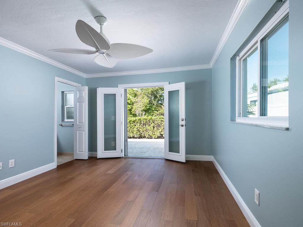 1036 Lake Shore Court Naples, FL 34103 - Photo 8 of 15 Empty room with a ceiling fan, crown molding, baseboards, and wood finished floors