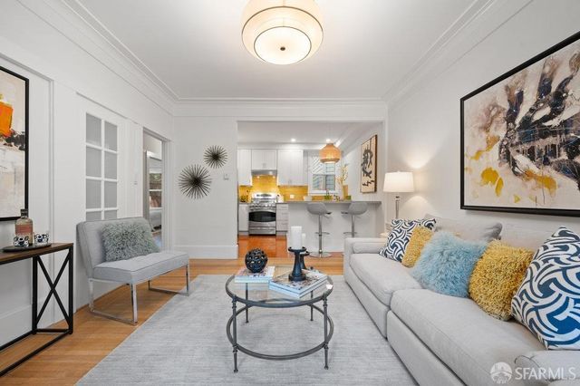 a living room with furniture and painting on the wall