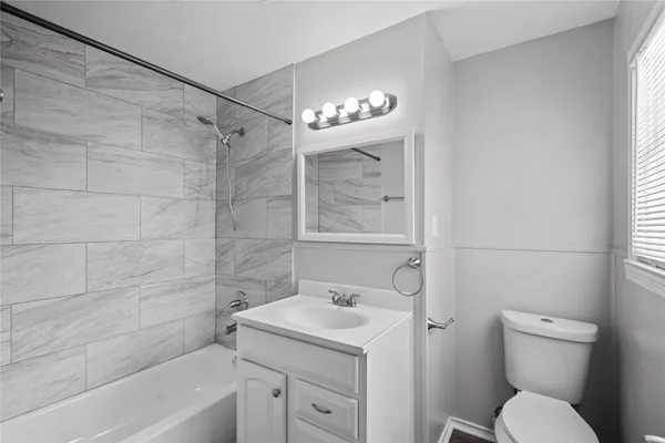 a bathroom with a granite countertop sink a toilet and shower